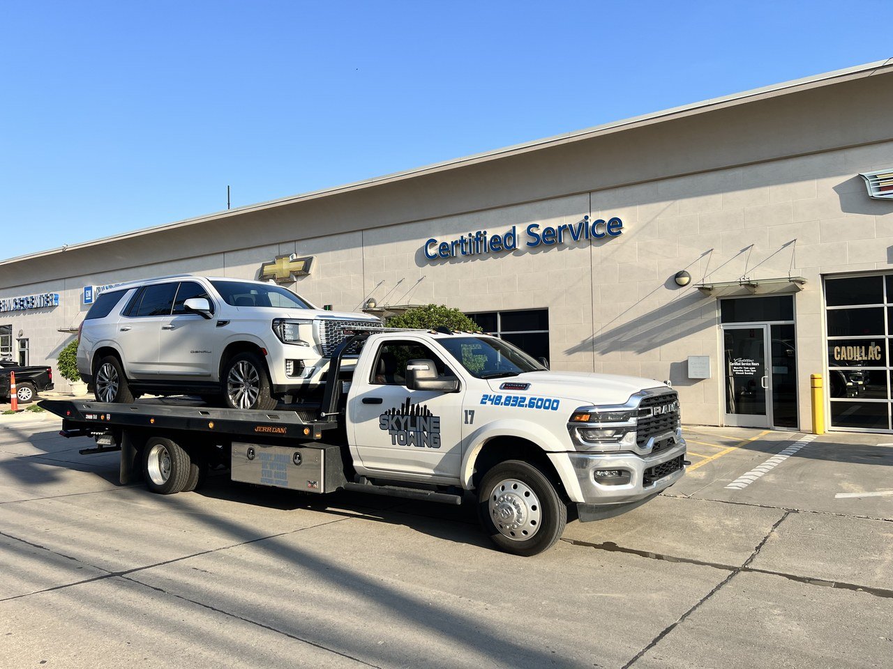 Skyline Towing flatbed delivering an SUV to a dealership service center